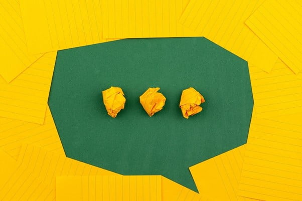 three crumpled yellow papers on green surface surrounded by yellow lined papers three crumpled yellow papers on green surface surrounded by yellow lined papers